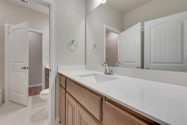 bathroom with tile patterned flooring, vanity, and toilet