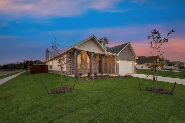 view of front of house with a yard and a garage