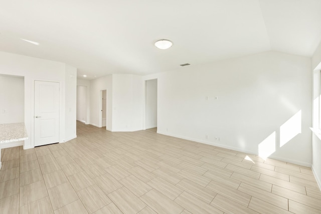 spare room featuring vaulted ceiling