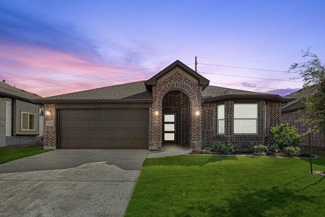 ranch-style home with a yard and a garage