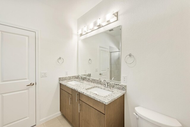 bathroom with vanity, walk in shower, tile patterned floors, and toilet