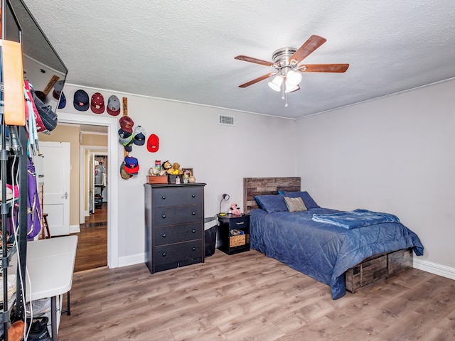 bedroom featuring a textured ceiling, ceiling fan, and hardwood / wood-style floors