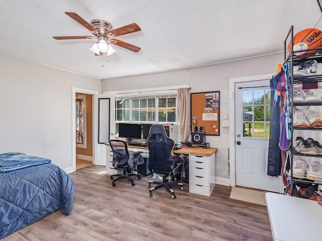 bedroom featuring hardwood / wood-style floors, ceiling fan, and a textured ceiling