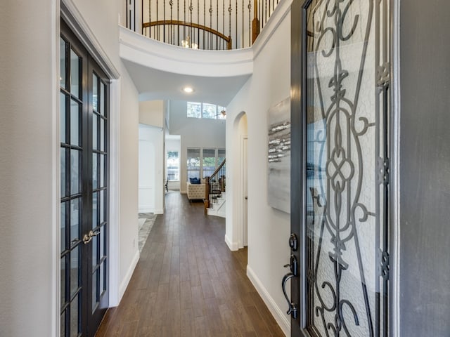 entrance foyer with a high ceiling, french doors, and dark hardwood / wood-style floors