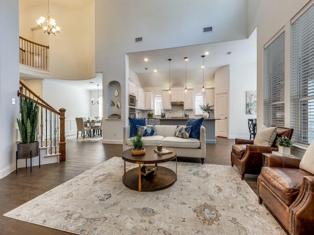 living room featuring a high ceiling, a notable chandelier, and dark wood-type flooring