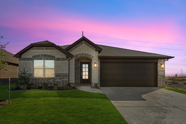 view of front of home with a garage and a lawn