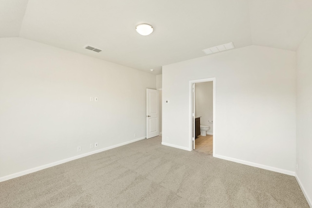 spare room with lofted ceiling and light carpet