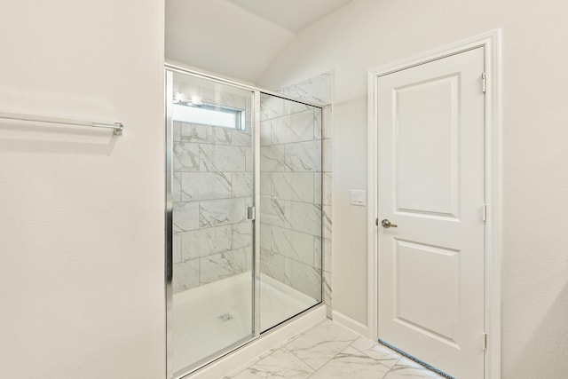 bathroom with a shower with shower door and vaulted ceiling