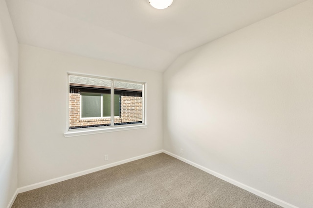 carpeted spare room featuring lofted ceiling