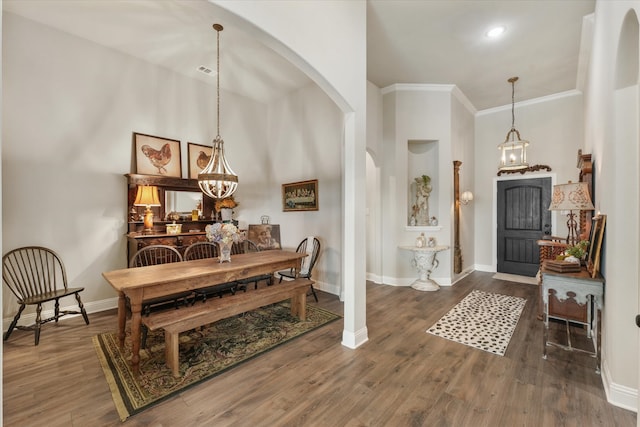 entryway with dark hardwood / wood-style flooring, an inviting chandelier, a high ceiling, and ornamental molding