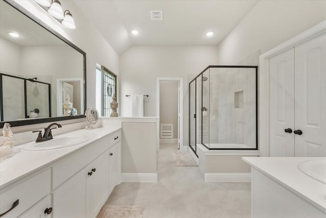 bathroom featuring vanity, vaulted ceiling, tile patterned floors, and a shower with shower door