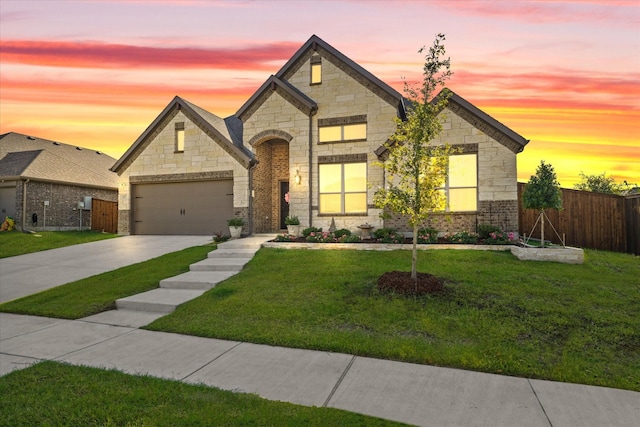 french country style house with a garage and a lawn