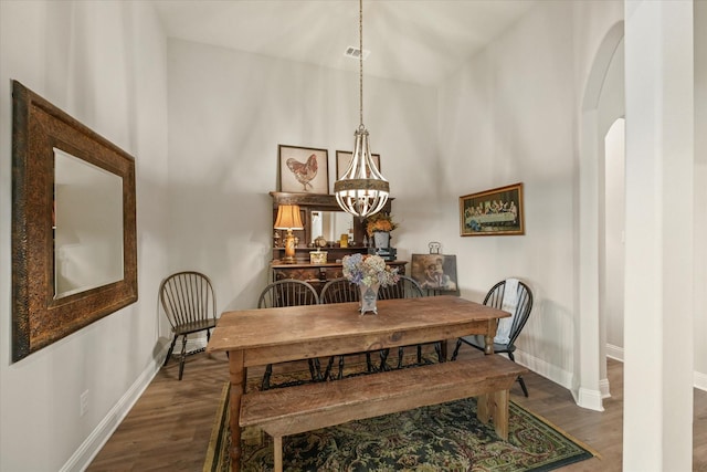 dining room featuring a notable chandelier, dark wood-type flooring, and a high ceiling