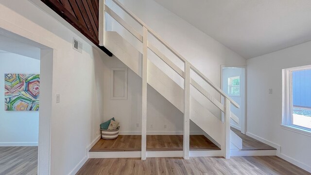 bonus room with light wood-type flooring and lofted ceiling