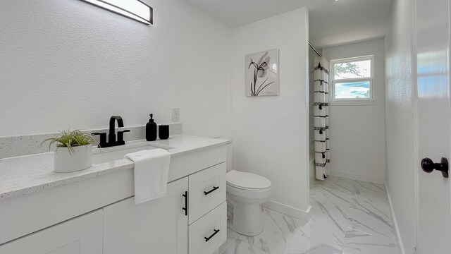 bathroom featuring vanity, toilet, and a shower