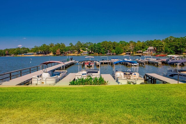 dock area with a lawn and a water view