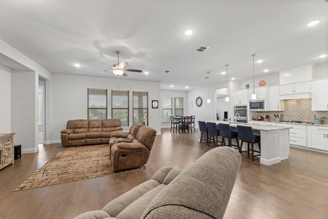 living room featuring light wood-type flooring and ceiling fan