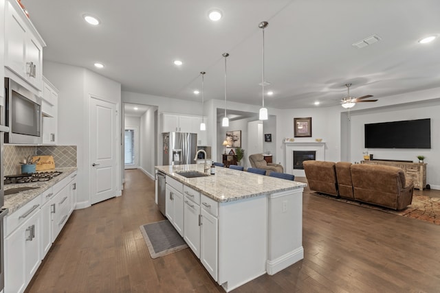 kitchen with dark hardwood / wood-style flooring, sink, ceiling fan, appliances with stainless steel finishes, and white cabinets