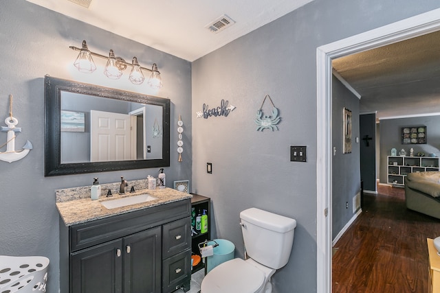 bathroom with vanity, toilet, and hardwood / wood-style floors