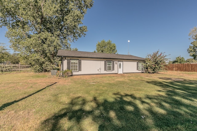 rear view of property featuring a yard