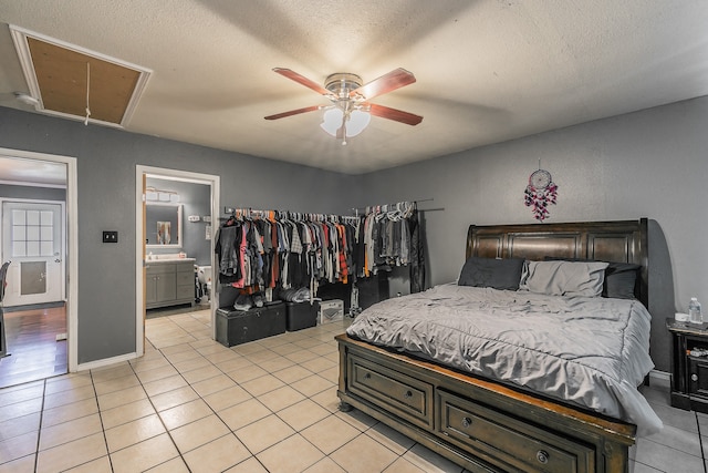 tiled bedroom featuring ensuite bath, a textured ceiling, and ceiling fan