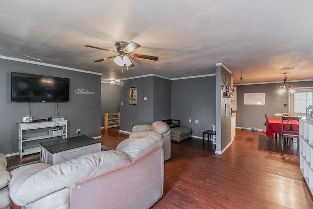 living room with dark wood-type flooring, ceiling fan with notable chandelier, and ornamental molding