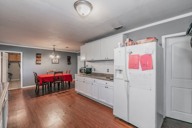 kitchen featuring dark wood-type flooring, white cabinets, decorative light fixtures, and white refrigerator with ice dispenser