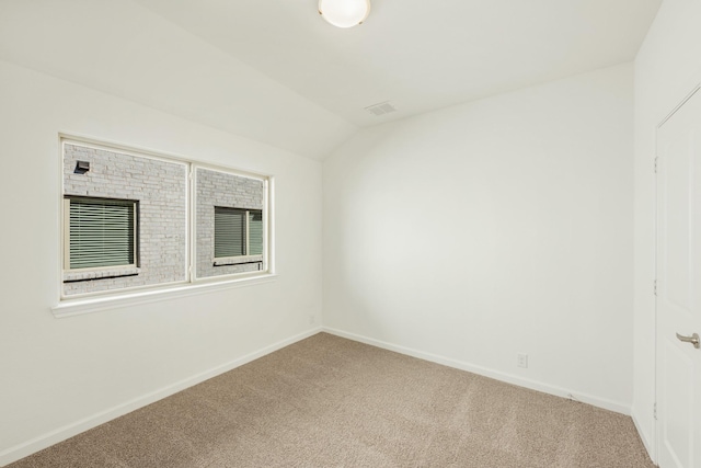 spare room with lofted ceiling and carpet flooring