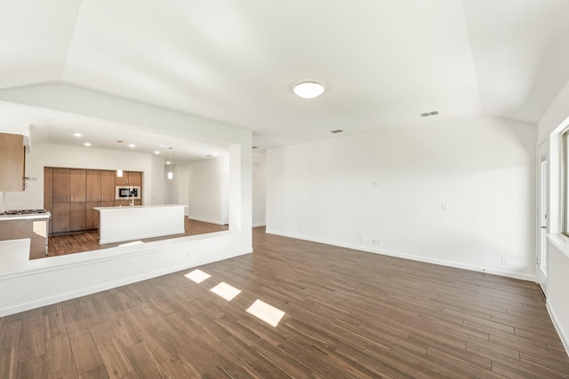 unfurnished living room featuring dark wood-type flooring and vaulted ceiling