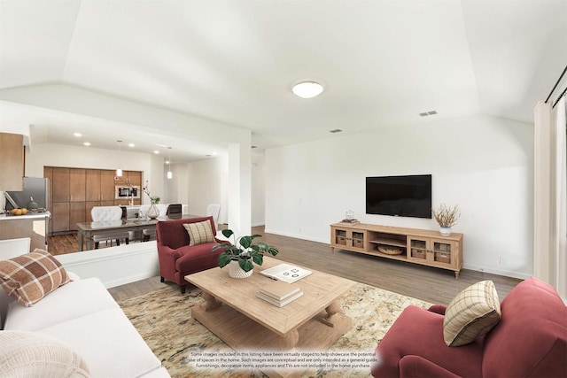 living room featuring lofted ceiling and hardwood / wood-style floors