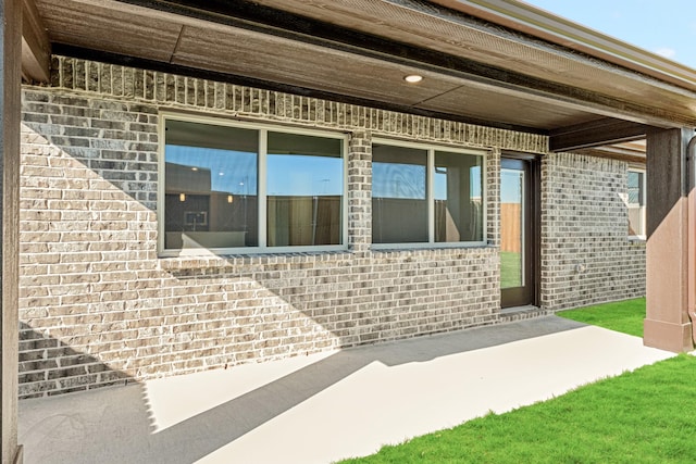 view of exterior entry with a patio area