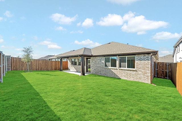 rear view of property featuring a lawn and a patio area