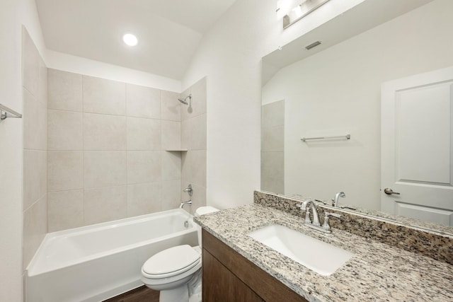 full bathroom featuring vanity, tiled shower / bath combo, vaulted ceiling, and toilet