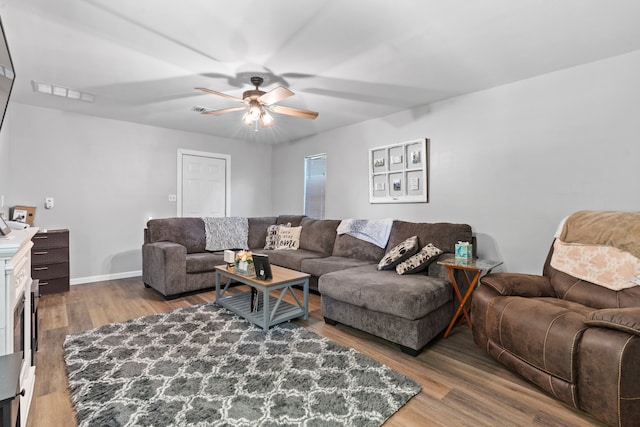 living room with wood-type flooring and ceiling fan