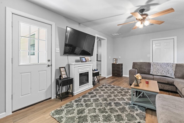 805 S 3rd St, Grandview, TX 76050 - living area with ceiling fan, visible vents, wood finished floors, baseboards, and a glass covered fireplace