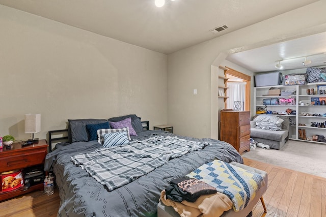 805 S 3rd St, Grandview, TX 76050 - bedroom featuring visible vents, arched walkways, and wood finished floors