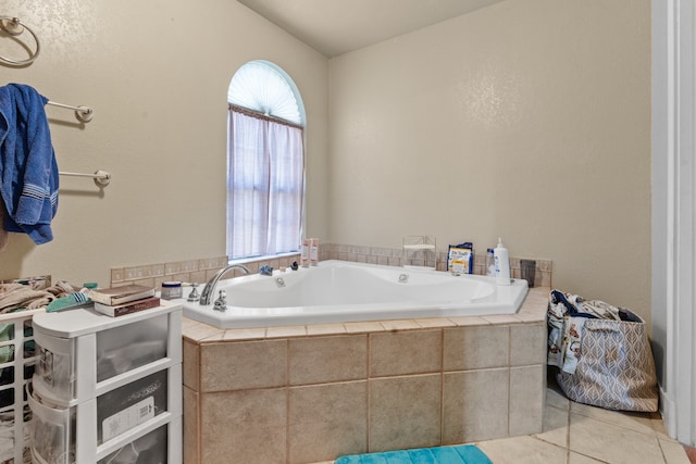 bathroom with tiled tub and tile patterned floors