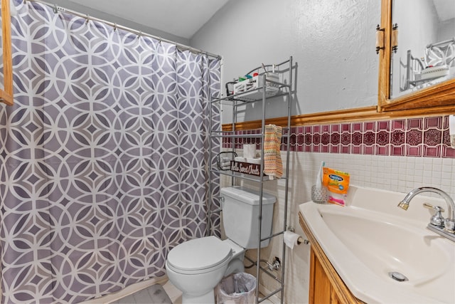 bathroom with tile walls, tile patterned flooring, toilet, and vanity