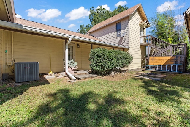 805 S 3rd St, Grandview, TX 76050 - back of property featuring stairs, roof with shingles, central air condition unit, and a yard