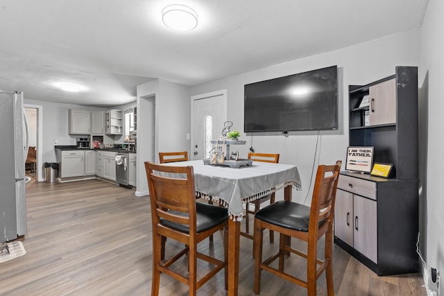 dining space with wood-type flooring