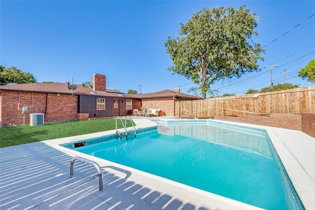 view of pool with a patio area, a yard, and central AC