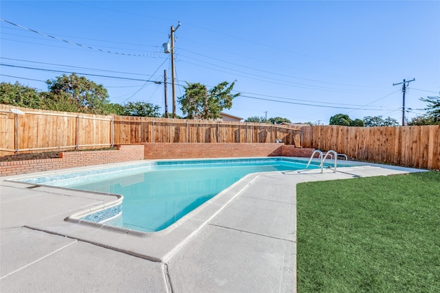 view of swimming pool with a yard and a patio area