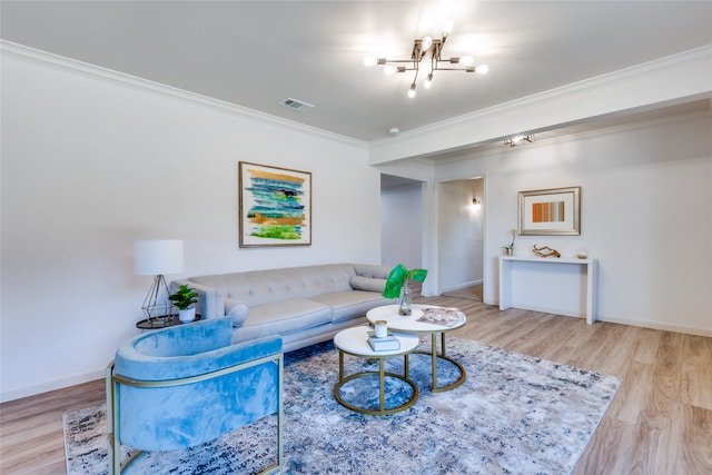 living room featuring crown molding, an inviting chandelier, and light hardwood / wood-style flooring