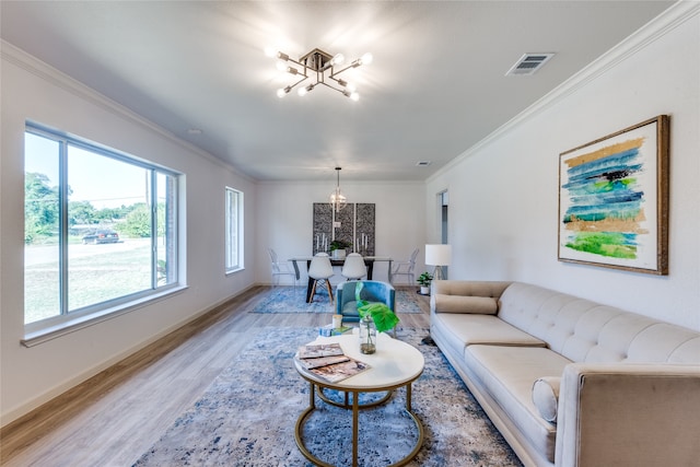 living room with ornamental molding, hardwood / wood-style flooring, and a notable chandelier