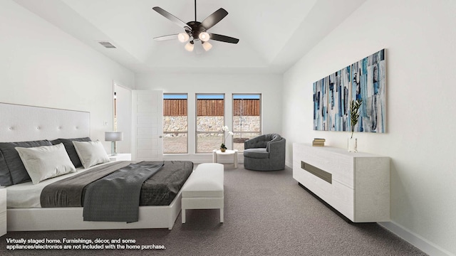 bedroom with ceiling fan, a tray ceiling, and carpet floors