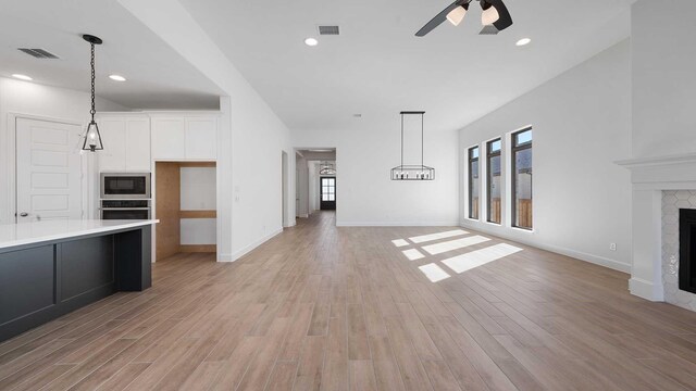 unfurnished living room featuring ceiling fan and light hardwood / wood-style flooring