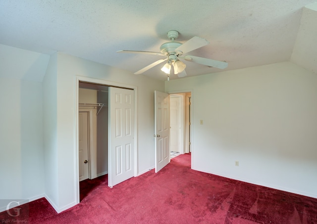 unfurnished bedroom with a textured ceiling, ceiling fan, a closet, lofted ceiling, and carpet floors