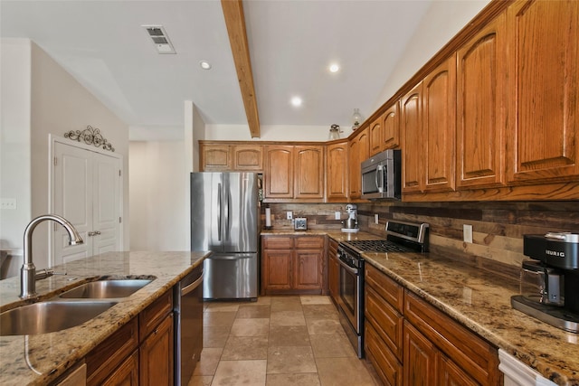 kitchen featuring lofted ceiling with beams, sink, light stone countertops, tasteful backsplash, and stainless steel appliances