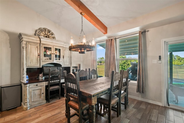 dining room featuring vaulted ceiling with beams and a chandelier