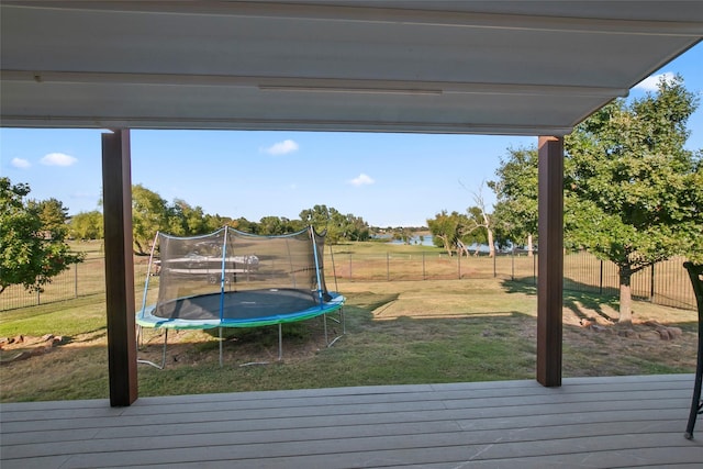 wooden terrace featuring a yard and a trampoline